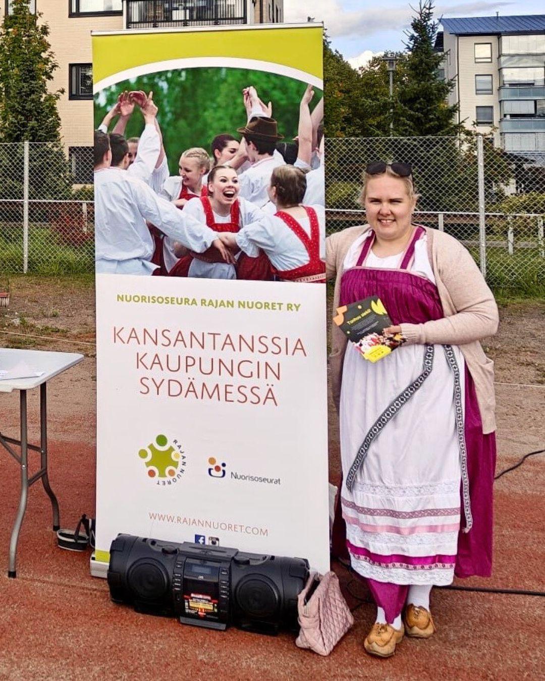 Olga Anttila seisomassa roll upin vieressä feresi päällään.