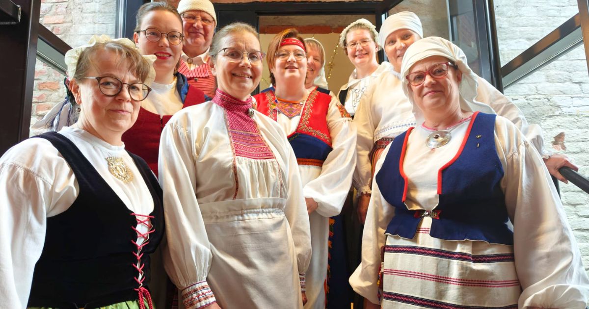 Kansallispukuisia henkilöitä ryhmäkuvassa.